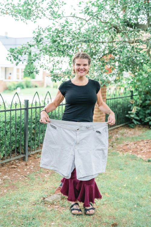 Anne Hoskins holding up pair of shorts from before her surgery to show weight loss comparison Anne Hoskins holding up pair of shorts from before her surgery to show weight loss comparison