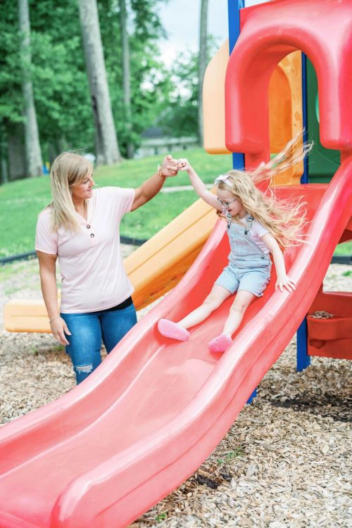 Corrie Cape and daughter on playground slide